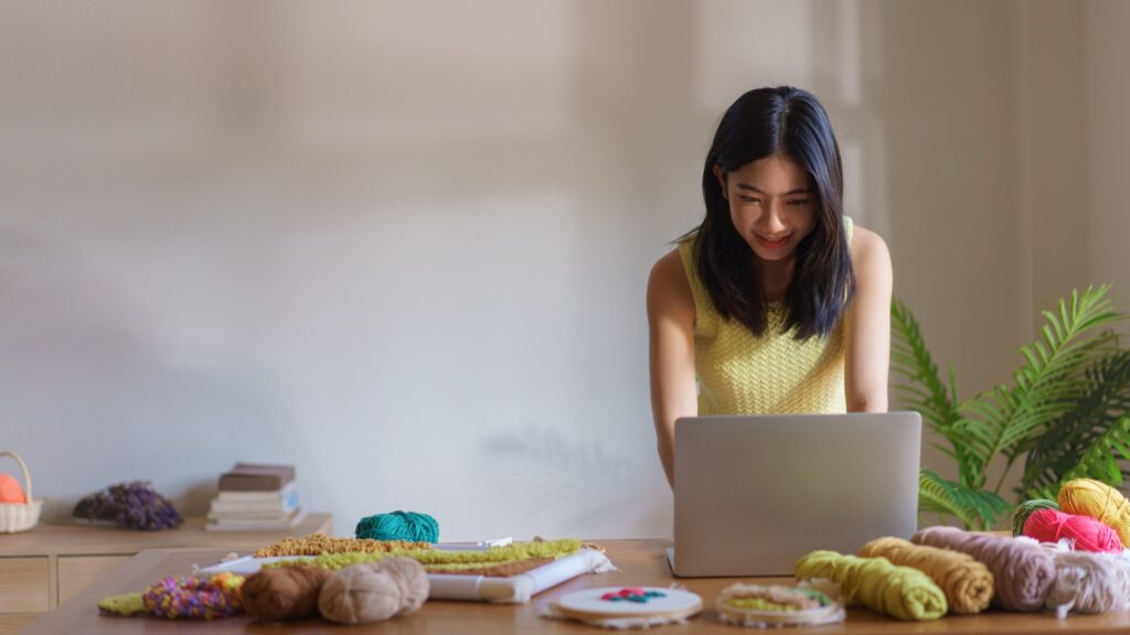 Hand embroidery concept, Women working on laptop and making handicraft embroidery with punch needle