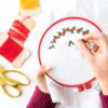 Hands making holly berries embroidery